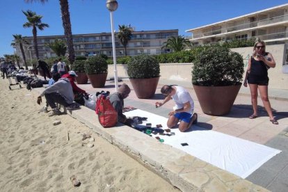 Un parell de turistes compren a les paradetes del 'top manta' que s'han adaptat a les jardineres.