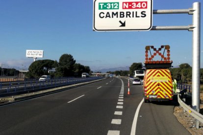 Un vehicle de Trànsit i dels Mossos escorten un bus averiat a l'AP-7 a Cambrils.