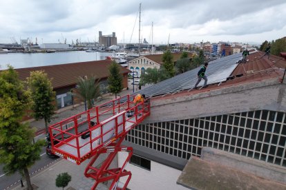 Operaris durant la instal·lació de plaques solars en un equipament del Port.