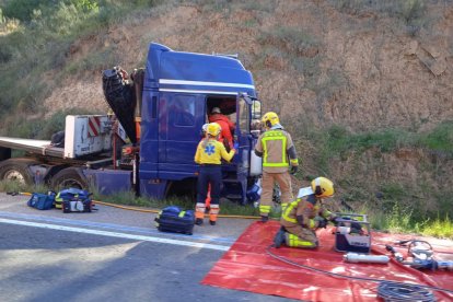 Els Bombers intentant alliberar el camioner atrapat a la cabina després de patir un accident a la C-12 a Tivissa.