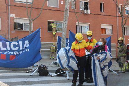 Imagen de una vecina siendo atendida en el incendio de un edificio de Rubí.