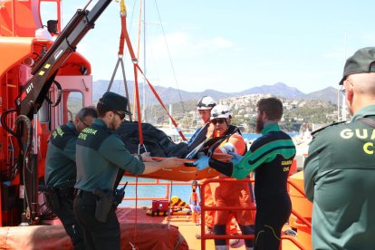 Efectius de la Guàrdia Civil, dels GEAS i de Salvament Marítim baixant el submarinista mort de l'embarcació.