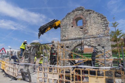 Los operarios instalando la reproducción pieza por pieza en una de las islas de la calle Mayor.