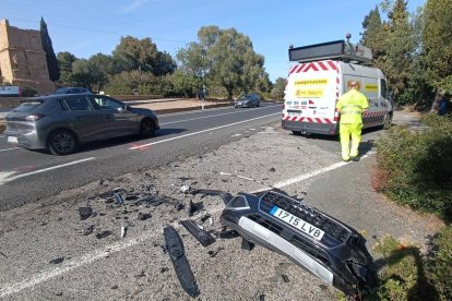 Els serveis de conservació de carreteres recullen les restes d'un dels vehicles implicats en l'accident.