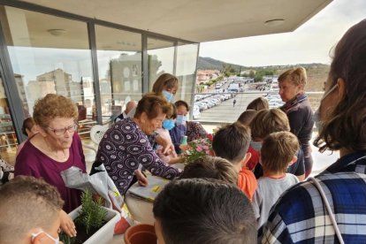 Escolars i gent gran van guarnir la terrassa del centre.