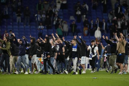 Algunos aficionados redicales del Espanyol invaden el campo tras el partido de contra el FC Barcelona en el RCDE Stadium.