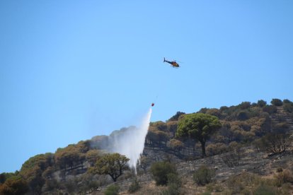 Un helicòpter descarregant en un dels focus de l'incendi de Portbou.