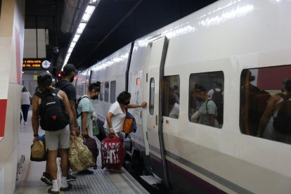 Passatgers pujant a un tren d'AVE a l'estació de Sants de Barcelona.