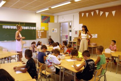 Imatge d'arxiu d'un grup d'infants fent activitats a l'aula amb llapis de colors.