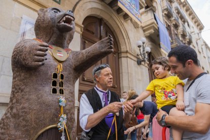 Un infant de Valls engalanant l'Os amb l'entrega dels xumets.