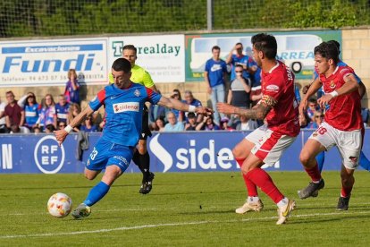 Joan Oriol i Nil Jiménez intentant bloquejar el remat del jugador de l'Amorebieta, Dorrio.