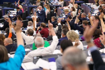 Eurodiputats al Parlament Europeu a Estrasburg, amb la mà alçada en una votació.