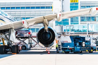 Imatge d'un treballador al costat d'un gran motor d'avió.