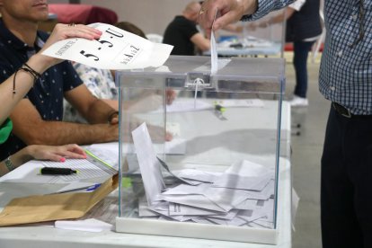 Una persona introdueix el seu vot en una urna del col·legi Fedac de Lleida.