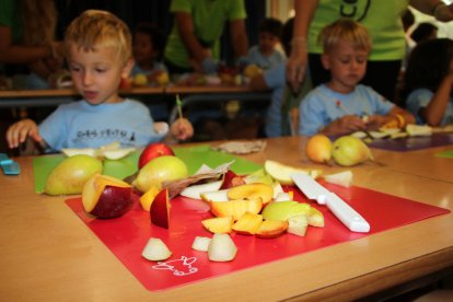 Fruta en primer término que han cortado los niños que han participado en el taller organizado por Unió de Pagesos en el casal de la Escuela Montsant de Reus.