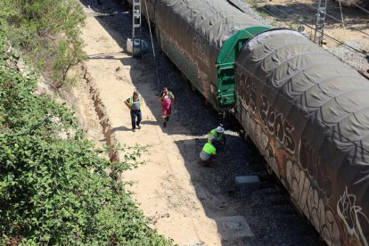 Operaris d'Adif treballant en el tren de mercaderies que ha descarrilat a l'estació Marçà-Falset.