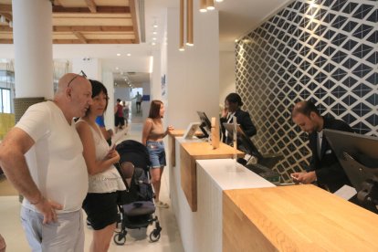 Uns turistes esperen ser atesos a la recepció de l'hotel Blaumar de Salou.