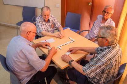 Uns jubilats que juguen al dòmino en un refugi climàtic.