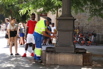 Un trabajador arregla una fuente en plena ola de calor.