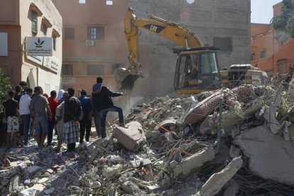 Una máquina excavadora ayuda en las tareas de búsqueda de supervivientes entre los escombros en la población de Amizmiz.