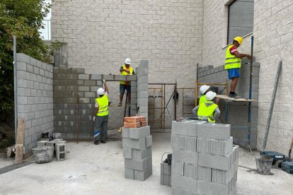 Els operaris treballant en la reconstrucció de la nau de la brigada municipal de Montblanc afectada per un incendi el 2021.