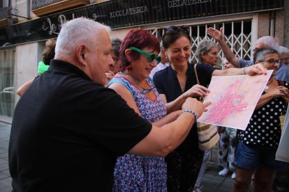 Tres personas mirando un mapa de la ciudad durante la ruta por la calle amplia organizada por l'Associació Espais Ocults en la novena edición de 'Reus Ocult'.