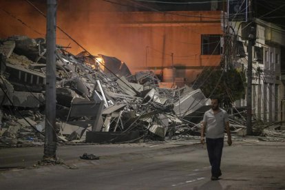 Un palestino pasa junto a las secuelas de un ataque aéreo israelí en la ciudad de Gaza.