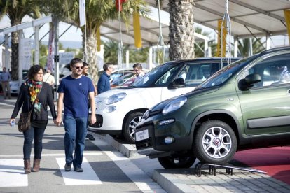 Imatge d'una parella de visitants mirant un vehicle en exposició durant una edició pasada de la fira ExproReus.