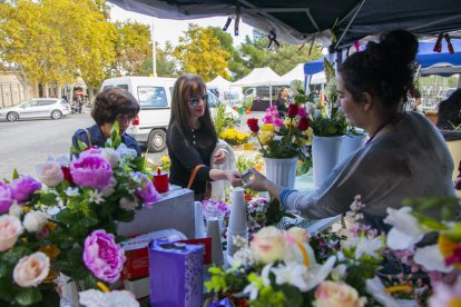 Imagen de archivo de clientes comprando flores en una parada en el cementerio de Tarragona.