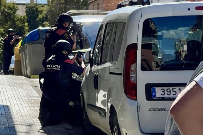 Agentes de los Mossos apuntan contra un domicilio de Terrassa donde se ha atrincherado un hombre después de disparar a otro.