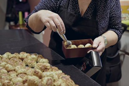 Imatge d'arxiu d'una pastissera preparant una safata de panellets de pinyons, un dels més demandats any rere any.