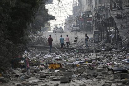 Un grupo de palestinos en una zona arrasada por los ataques israelíes en Gaza.