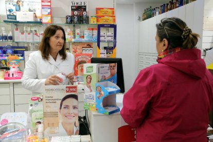 Imatge d'arxiu d'una farmacèutica parlant amb una clienta.