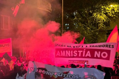 Pancartas contrarias a la amnistía rodeadas de humo cerca de la sede del PSOE en la calle Ferraz de Madrid, el pasado 7 de noviembre.