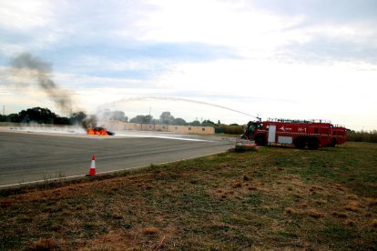 Imagen del vehículo que se ha incendiado, simulando que era un avión, durante el simulacro de accidente aéreo en el aeropuerto de Reus.