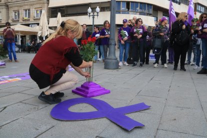 Una dona col·loca una rosa per homenatjar a les víctimes de violència masclista, en l'acció reivindicativa a Tarragona amb motiu del 25-N.