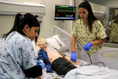 Dues infermeres pediàtriques fan pràciques a les aules de simulació de la URV.