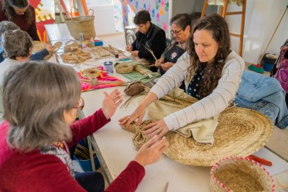 Assistents del taller obert treballant en les seves cistelles.