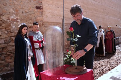 El president de l'Associació Medieval de la Llegenda de Sant Jordi, Maties Martí, col·loca la primera rosa de Catalunya en un recipient de vidre.