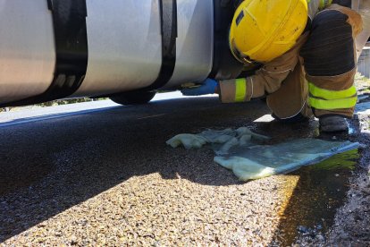 Imatge dels bombers tapant la fuita de gasoil del camió.