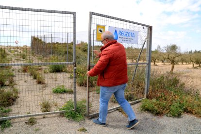 Un treballador obre la tanca d'una bassa de reg de la comunitat de regants de la Terra Alta.