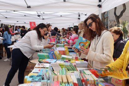 Diverses persones mirant llibres a la parada de La Capona a Tarragona.