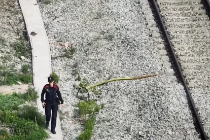 Una agent de Mossos comprovant un robatori de cable de coure d'una infraestructura ferroviaria.