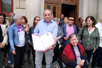 Un dels familiars d'una usuària de la residència de Reus mostrant les signatures recollides per aturar el trasllat dels residents a altres centres.