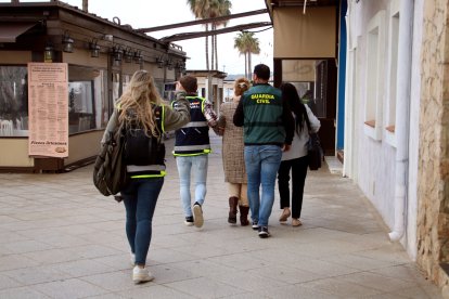 Imatge d'arxiu d'una dona detinguda sent custodiada per agents de la Guàrdia Civil i la Policia Nacional en una operació conjunta a Torredembarra relacionada en una trama suposadament amb explotació laboral