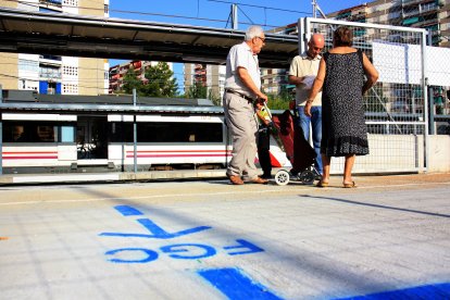 Un home indica uns usuaris d'edat avançada com han d'anar a Barcelona a l'estació de Bellvitge