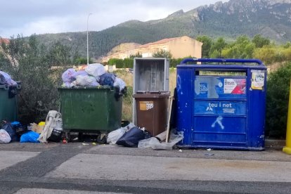 Contenidors de rebuig a vessar en una urbanització de Mont-roig del Camp.