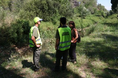 Un parell d'informadors ambientals conversen amb visitants de l'Albereda de Santes Creus.