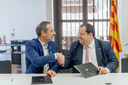 El conseller d'Interior, Joan Ignasi Elena i el president del Consell Comarcal, Sergi Méndez, durant la signatura del conveni.