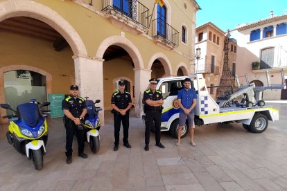 Imatge dels tres nous agents de la Policia d'Altafulla i la nova grua municipal.